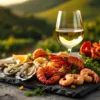 Glas witte Braziliaanse wijn naast luxe zeevruchtenplateau met oesters, garnalen en kreeft op donkere leisteen